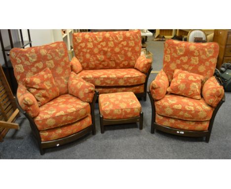 A dark oak Ercol double sofa , upholstered in tones of terracotta; a pair of conforming armchairs, with stuffed footstool (4)