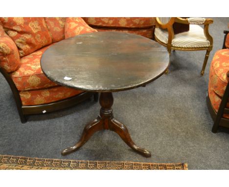 A late 18th Century oak tilt top tripod table, circular top, baluster column, tripod feet