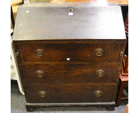 A 19th century stained pine bureau, fall front, enclosing three drawers, stylish circular Arts and Crafts escutcheon, bracket