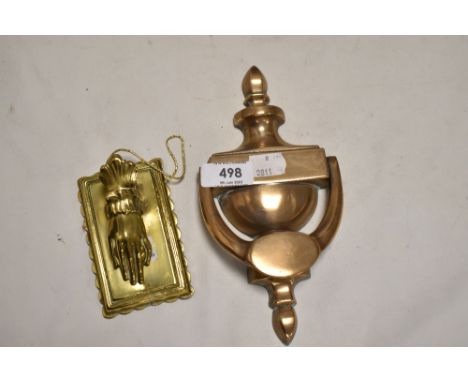 A cast brass door knocker and a brass memo holder in the form of a hand.