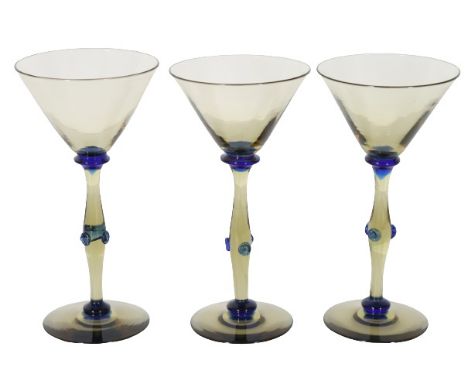 Three Steuben cocktail glasses with a yellow hue and blue details. Size: 7 x 3 1/2 in. Please note that all sales are final. 