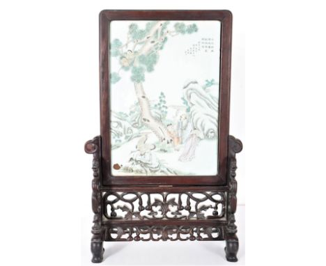 Porcelain table screen with mahogany frame, tile depicts a shade pine-tree with rocky hills in the background symbolizing lon