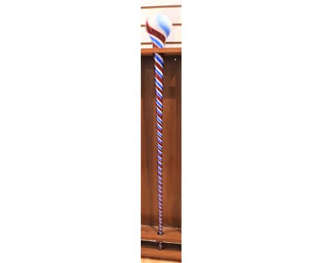 This is a free-blown glass walking stick with a white colored interior and red and blue swirled detail running down the entir