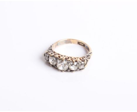 A late Victorian gold and diamond five stone carved half-hoop ring with rose diamond points, the graduated old-cut stone is a