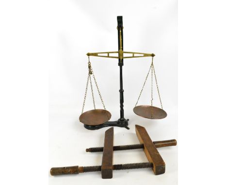 A green painted wrought iron and brass set of balance scales stamped "C.W.S. Manchester", height 74cm, and a beech woodworkin