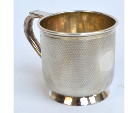 A George V hallmarked silver christening cup with overall engine turned decoration and loop handle, on tapering foot, Deakin 