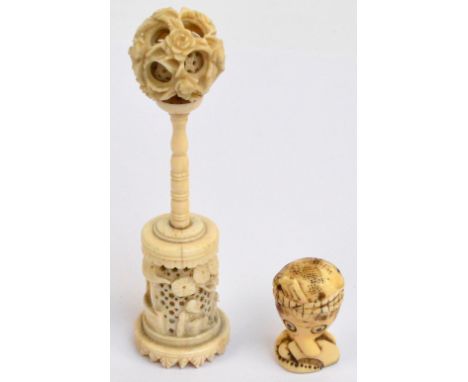 A late 19th century Chinese carved bone puzzle ball on stand, height 12cm, and a Japanese Meiji period marine ivory netsuke m