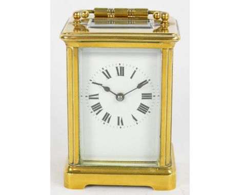 A c.1900 French brass carriage clock with rectangular white enamel dial set with Roman numerals and with swing loop handle, w