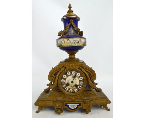 A 19th century French gilt metal porcelain mounted mantel clock, the raised gilt heightened finial decorated with cherubs and