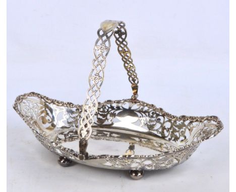 An Edward VII hallmarked silver bread basket of oval form with shaped lozenge pierced scroll decorated sides and cast rims, w