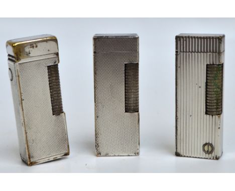 Three engine turned decorated chromed Dunhill lighters.