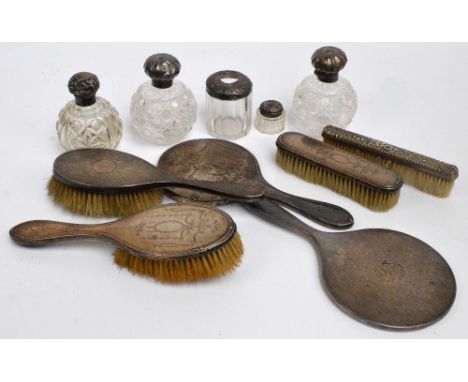 A George V hallmarked silver backed three piece dressing table set comprising a circular hand mirror, length 26cm, a hand bru