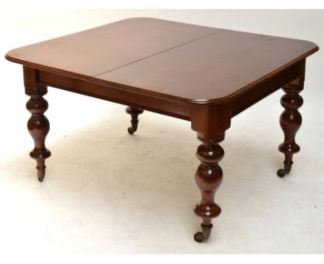 A Victorian mahogany extending dining table, the rounded rectangular top with three additional leaves raised on baluster turn
