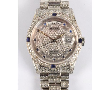ROLEX; an 18ct white gold day/date wristwatch with diamonds and sapphires set throughout, inner case numbered 18200, bracelet