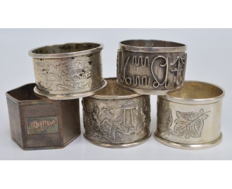A group of five napkin rings comprising variously hallmarked English silver examples, including a hexagonal overall engine tu