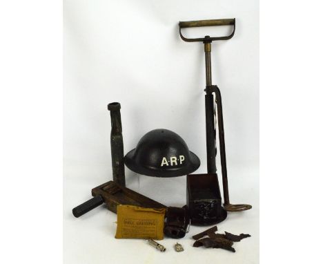 A collection of WWII related military items including an A.R.P. helmet, a collection of shrapnel, an A.R.P. whistle, a shell 