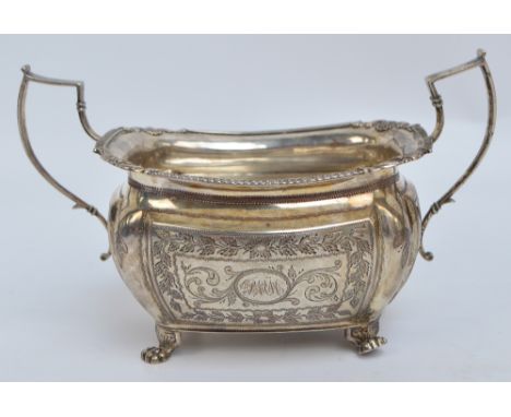 A George IV Irish hallmarked silver twin handled sugar bowl of rounded rectangular form, the body engraved with scrolls and f