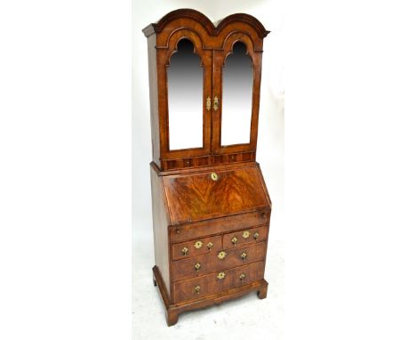 A George I style walnut and feather banded double domed bureau bookcase of small proportions, the moulded cornice above two s