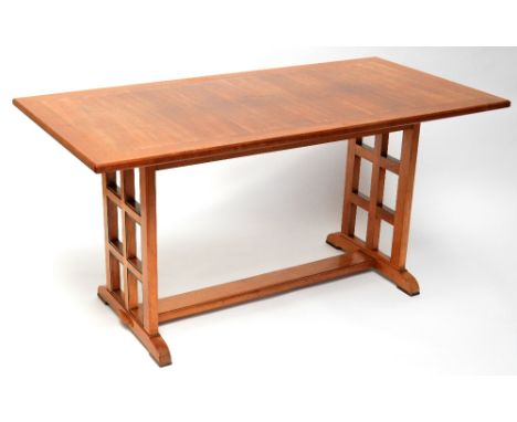 An Arts and Crafts walnut refectory table, the broad crossbanded top raised on lattice work open end supports united by a cen