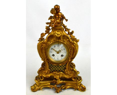 A 19th century French gilt metal mantel clock, the case with putti finial above a white enamelled dial painted with floral sw