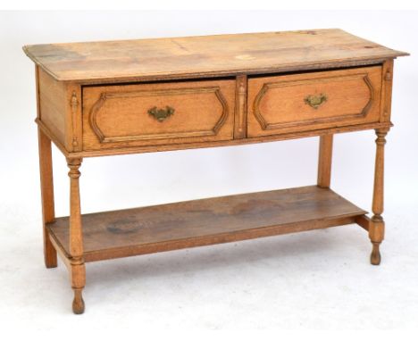 An early 20th century light oak two drawer dresser base raised on baluster block supports (af), width 138cm.