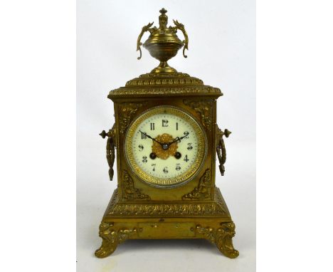 A late 19th century French brass mantel clock, the urn finial above rectangular case set with circular dial housing an eight 
