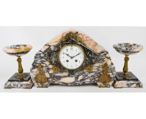 A French Art Deco style pink marble eight day mantel clock of shaped form with white enamel dial set with Arabic numerals, wi