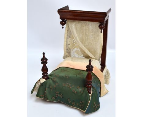 A Victorian mahogany half tester doll's bedstead with turned finials, with silk bed throw and lace details, height 34cm, leng