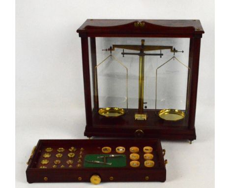 A mahogany cased set of laboratory scales mounted on a shelf set with a large collection of graduated weights, width of case 