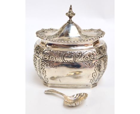 A Victorian hallmarked silver tea caddy of shaped octagonal form with domed hinged lid surmounted with cast finial and cast g