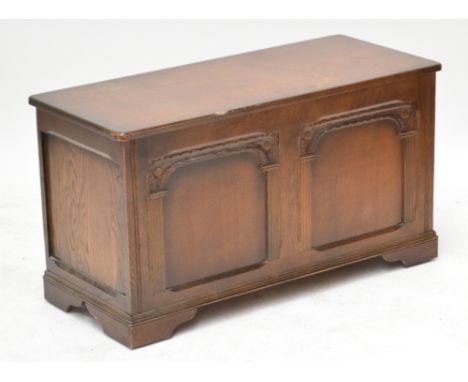 An early 20th century oak blanket box with two carved panels to the front, on bracket feet, 95 x 42cm, height 51.5cm.