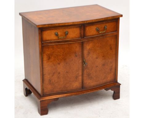 A reproduction serpentine front cabinet with two drawers above a pair of doors, on bracket feet, width 74.5cm, height 75.5cm.
