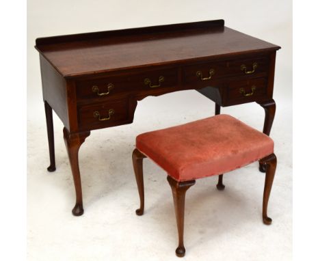 An Edwardian mahogany writing desk, the moulded rectangular top above an arrangement of four short drawers raised on cabriole
