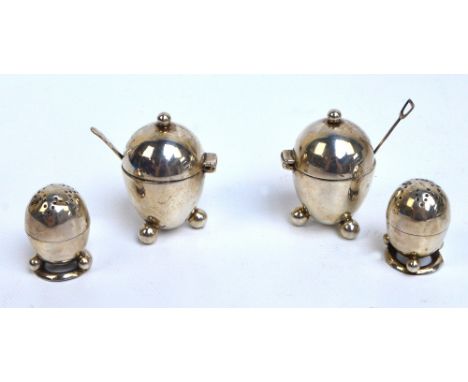 A pair of Victorian hallmarked silver egg shaped mustard pots, crested with a seated leopard to the hinged lids with spherica