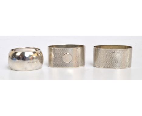 A pair of George VI hallmarked silver oval napkin rings with overall engine turned decoration centred with a vacant circular 