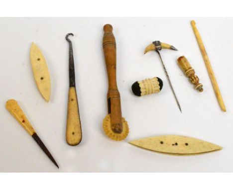 A small group of bone sewing tools including a crochet hook, a piercer, a pin cushion etc, also a white metal mounted bow sha