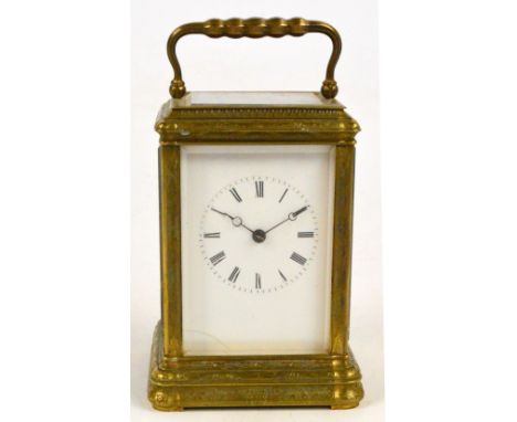 A late 19th century French brass carriage clock, the swing loop handle above foliate engraved case, the rectangular enamel di