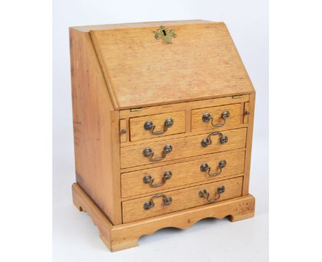 A 20th century mahogany miniature bureau with fall front enclosing a fitted interior above two short and three long drawers o