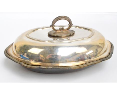 A George V hallmarked silver entree dish with cover and separate handle, of shaped oval form with gadrooned rim, dish and cov