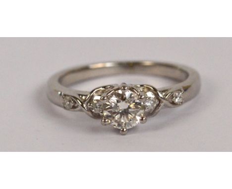 A platinum and diamond ring, the principal stone weighing approx 0.5cts with tiny diamonds to the shoulders, size K, approx 4