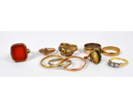 A collection of gold rings including a three strand three tone 18ct gold ring, size S, an 18ct and platinum three stone diamo