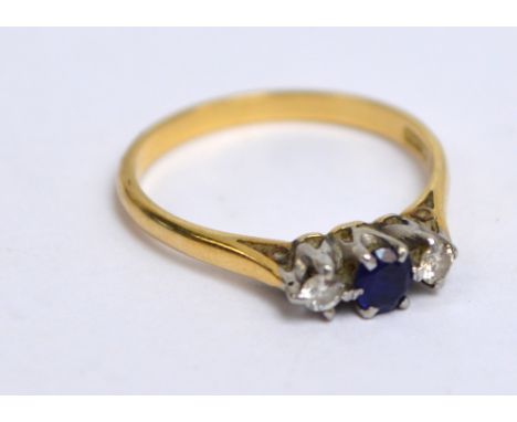 An 18ct yellow gold diamond and sapphire three stone ring, the central sapphire flanked by diamonds in high claw setting, siz