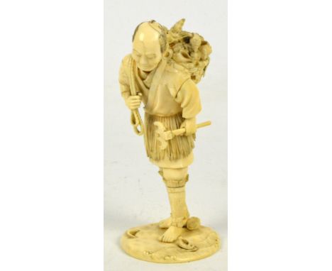 A Japanese Meiji period ivory sectional okimono depicting a shell collector with a basket of shells on his back and a scrapin