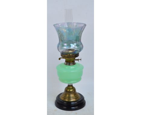 A Victorian brass mounted oil lamp with green semi-opaque reservoir and lustre glazed flared shade, height 47cm (excluding fu
