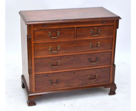 A George III style mahogany and crossbanded chest of drawers, the moulded rectangular top above brushing slide, two short and
