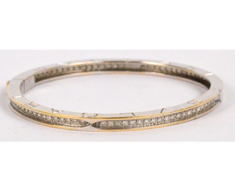 BULGARI; a white metal hinged bangle channel set throughout with diamonds and inscribed "Bulgari" to either side of both hing