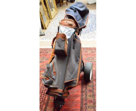 A modern electric golf motor caddy, and a modern set of Ping golf clubs. CONDITION REPORT: Golf clubs are Ping IST.K.