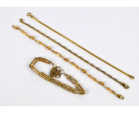 Three 9ct yellow gold bracelets, including a shaped gate link charm bracelet with heart shaped padlock and a marine link exam