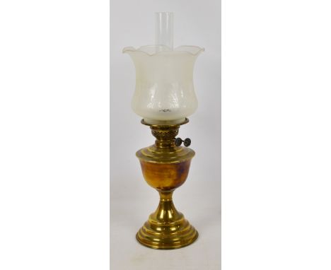 A c.1900 brass oil lamp with Art Nouveau decorated part frosted shade and spreading circular foot, height including funnel 56
