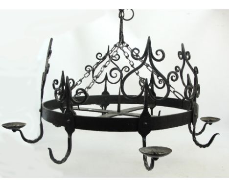 A wrought iron circular chandelier with four candles holders alternating with four hooks, with scroll decorated heart motifs 